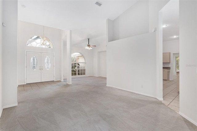 entryway with light carpet, high vaulted ceiling, and ceiling fan