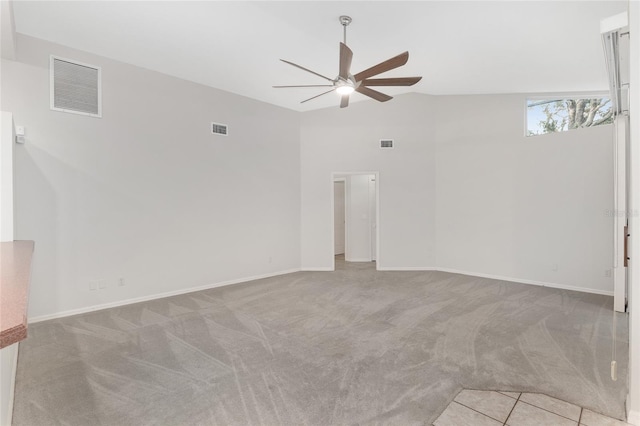 empty room with ceiling fan, light colored carpet, and lofted ceiling