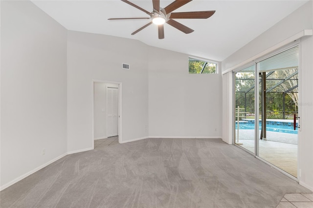 spare room with ceiling fan, lofted ceiling, and light carpet