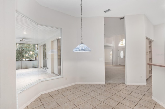 unfurnished dining area featuring ceiling fan and light tile patterned flooring