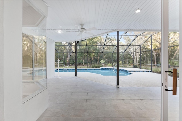 view of swimming pool featuring ceiling fan, a patio area, and a lanai