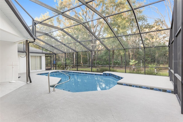 view of pool with glass enclosure and a patio area