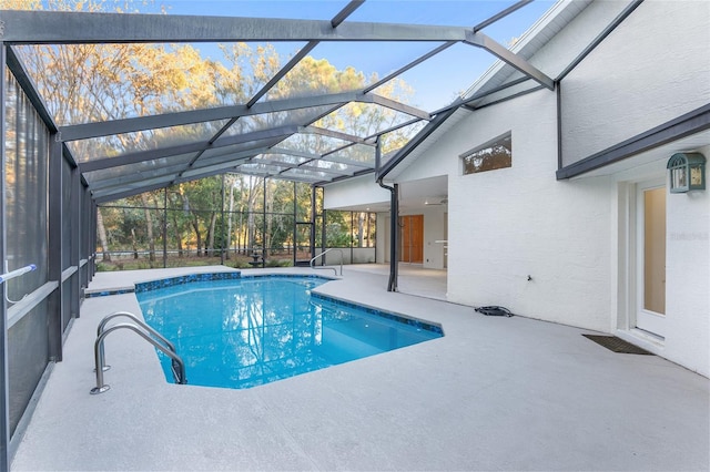 view of swimming pool with glass enclosure and a patio area