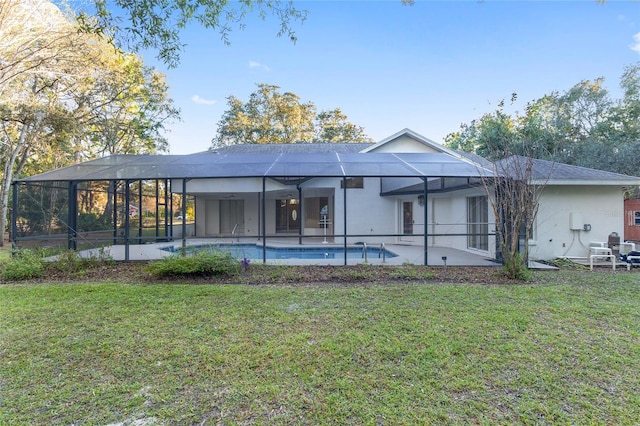 rear view of house featuring a lanai, a yard, and a patio