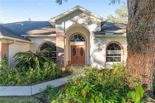 2843 W Elm Blossom St, Beverly Hills, FL 34465 - entrance to property featuring roof with shingles, brick siding, and stucco siding
