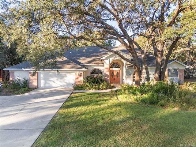 2843 W Elm Blossom St, Beverly Hills, FL 34465 - view of front of house featuring concrete driveway, an attached garage, a front yard, stucco siding, and roof with shingles