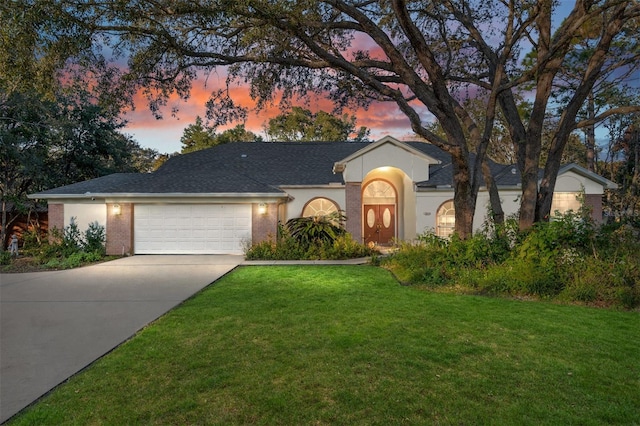 2843 W Elm Blossom St, Beverly Hills, FL 34465 - view of front of house featuring an attached garage, a lawn, concrete driveway, and stucco siding
