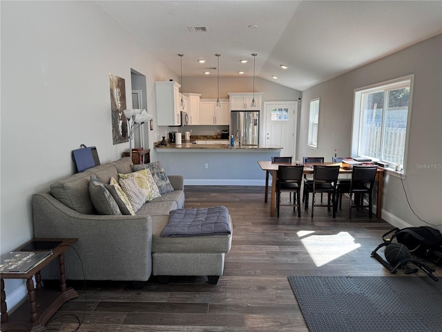 living room featuring dark hardwood / wood-style floors, lofted ceiling, and sink