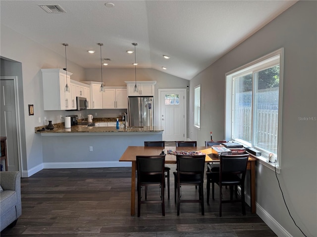 dining area with dark hardwood / wood-style flooring and vaulted ceiling