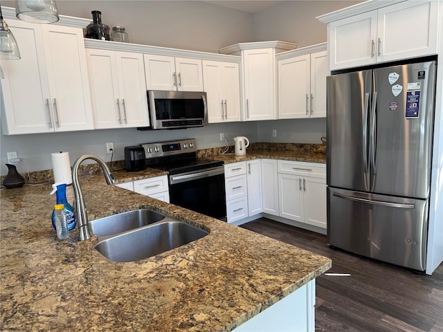 kitchen with appliances with stainless steel finishes, dark hardwood / wood-style floors, white cabinetry, and sink