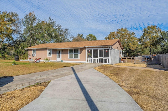 single story home featuring a sunroom and a front yard