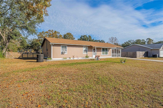 single story home featuring a sunroom, central AC unit, and a front yard