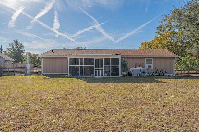 back of property featuring a sunroom and a yard