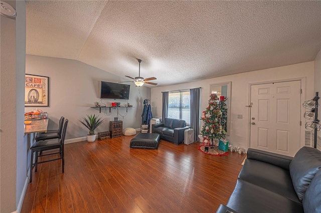 living room featuring a textured ceiling, ceiling fan, vaulted ceiling, and hardwood / wood-style flooring