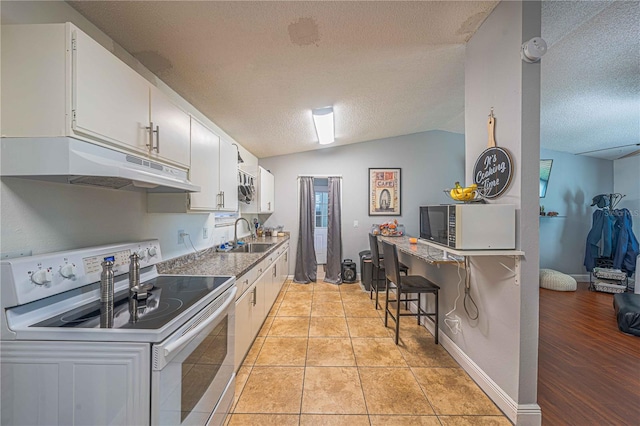 kitchen with sink, light hardwood / wood-style flooring, white cabinets, white range with electric cooktop, and lofted ceiling