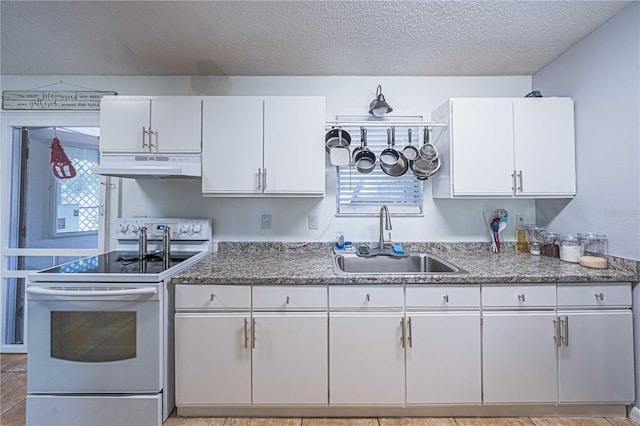 kitchen featuring white range with electric cooktop, white cabinetry, sink, and a textured ceiling