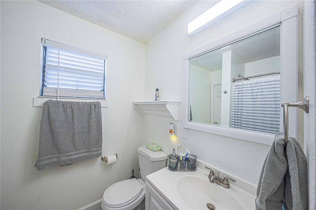 bathroom featuring vanity, toilet, and a textured ceiling