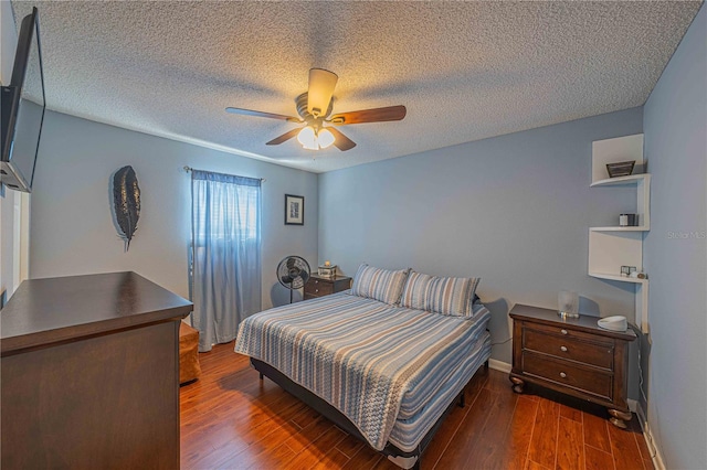 bedroom featuring ceiling fan, dark wood-type flooring, and a textured ceiling