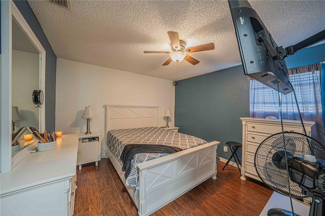 bedroom with a textured ceiling, dark hardwood / wood-style flooring, and ceiling fan