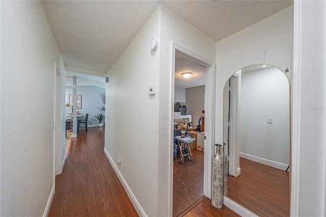 hallway featuring dark wood-type flooring and a textured ceiling