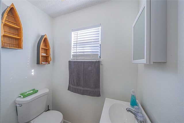 bathroom featuring sink, toilet, and a textured ceiling