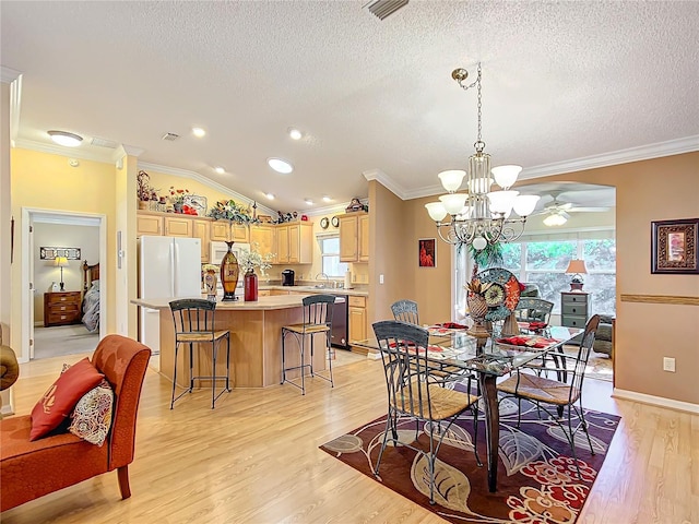 dining area with ornamental molding, a textured ceiling, ceiling fan with notable chandelier, vaulted ceiling, and light hardwood / wood-style flooring