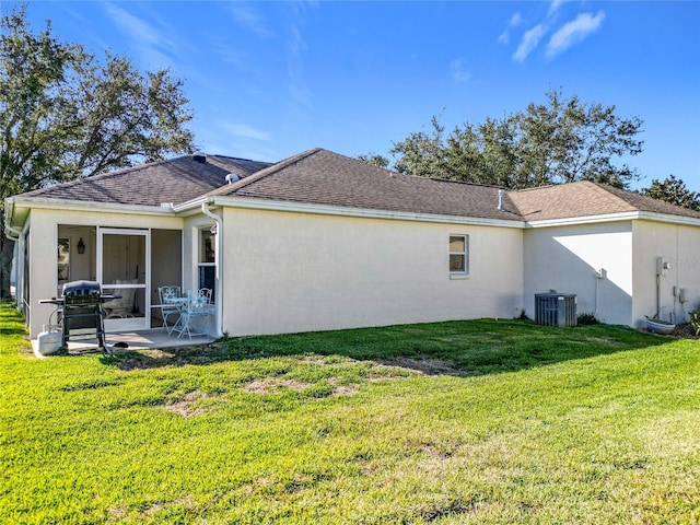 rear view of property featuring central air condition unit, a lawn, and a patio