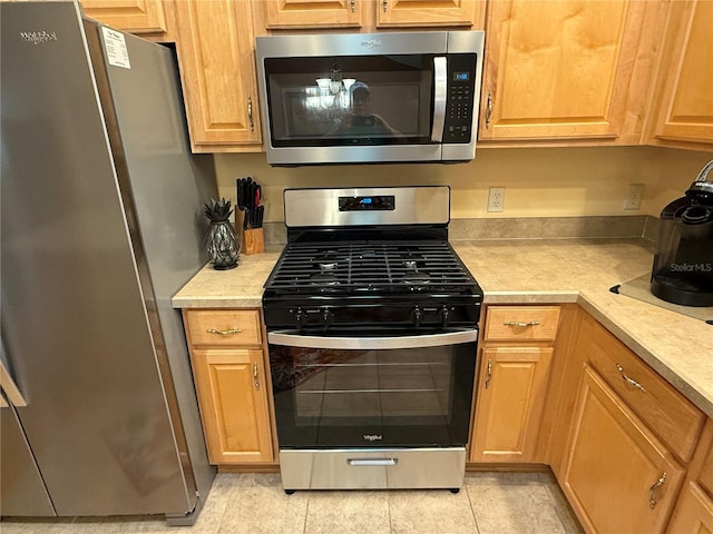 kitchen with light tile patterned floors and stainless steel appliances