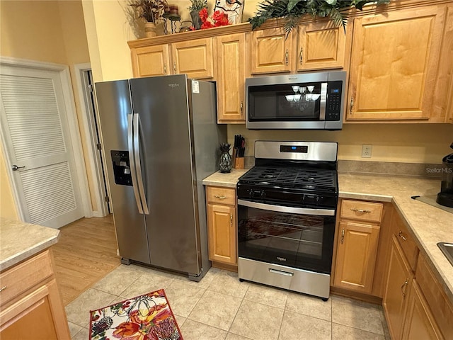 kitchen with light tile patterned floors and stainless steel appliances