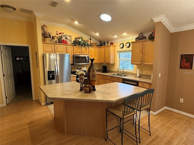 kitchen featuring a center island, sink, stainless steel appliances, and vaulted ceiling