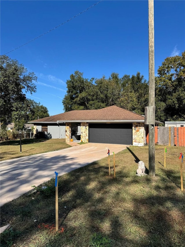 ranch-style home featuring a garage and a front lawn