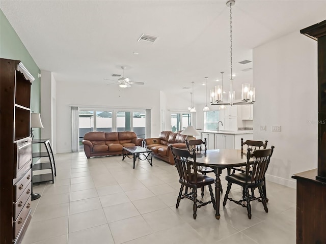 dining room featuring ceiling fan, light tile patterned flooring, and sink