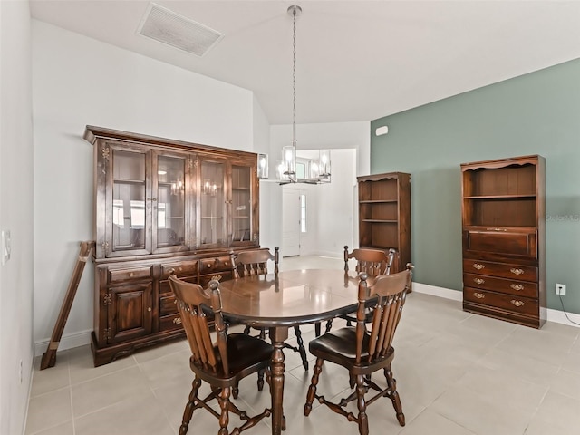 dining area featuring light tile patterned floors, lofted ceiling, and a notable chandelier