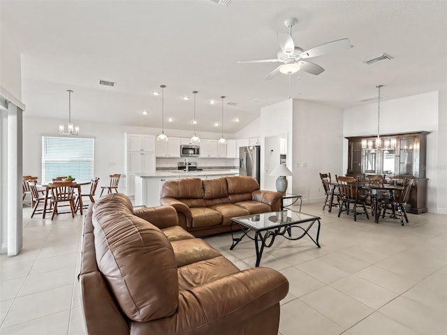 living room featuring vaulted ceiling, sink, light tile patterned floors, and ceiling fan with notable chandelier