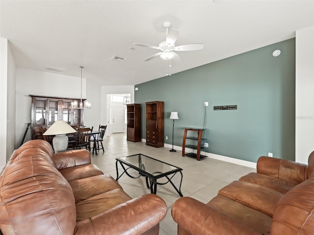 living room with lofted ceiling, light tile patterned floors, and ceiling fan with notable chandelier