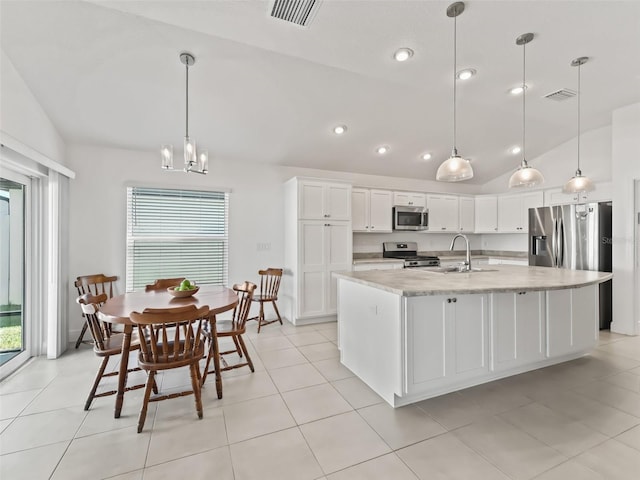 kitchen featuring a center island with sink, white cabinets, stainless steel appliances, and lofted ceiling