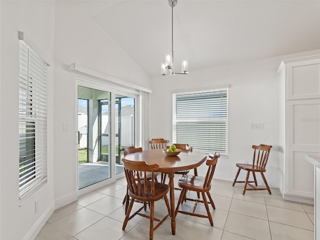 tiled dining room featuring a chandelier and lofted ceiling