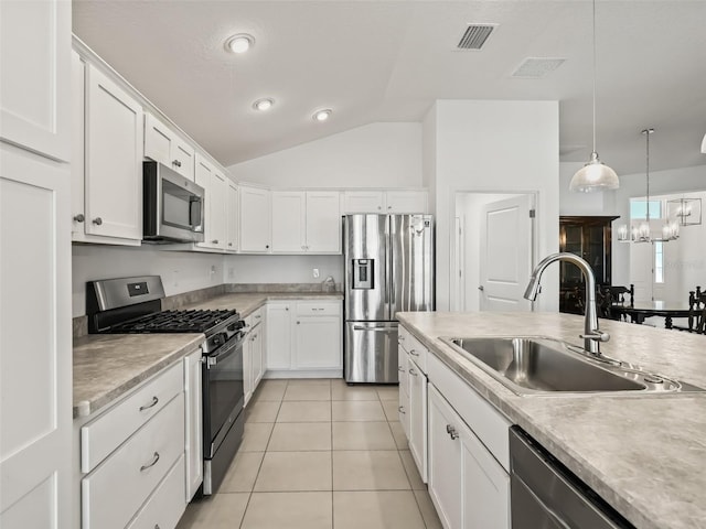 kitchen featuring sink, white cabinetry, stainless steel appliances, and vaulted ceiling