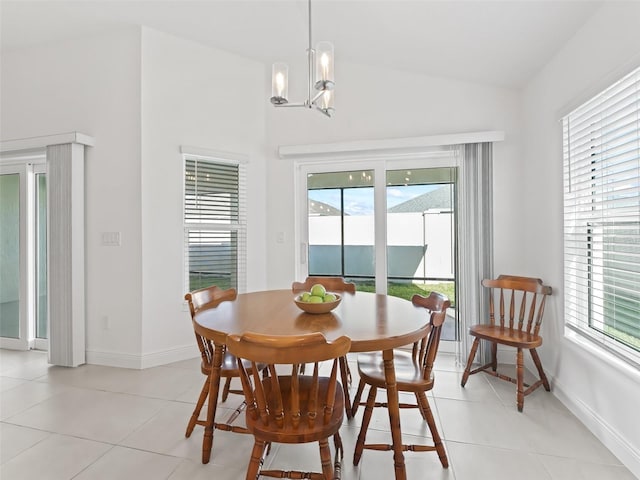 tiled dining area featuring an inviting chandelier, vaulted ceiling, and plenty of natural light