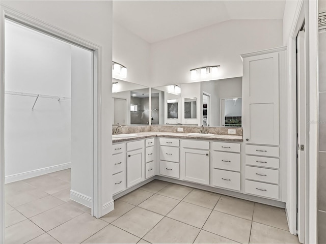 bathroom with tile patterned flooring, vanity, and vaulted ceiling