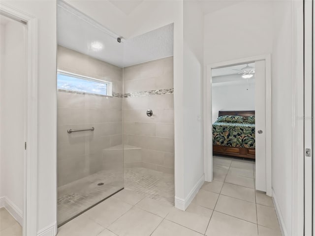 bathroom with tile patterned flooring, ceiling fan, and a tile shower