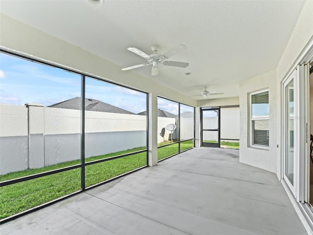 unfurnished sunroom with ceiling fan and a healthy amount of sunlight