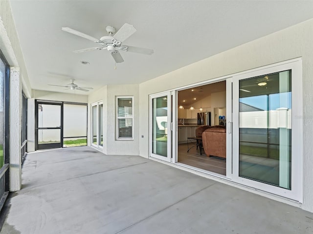 unfurnished sunroom with ceiling fan