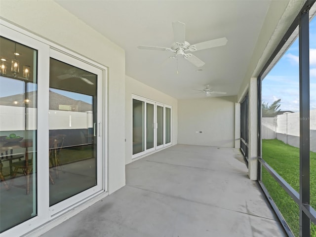 unfurnished sunroom with ceiling fan