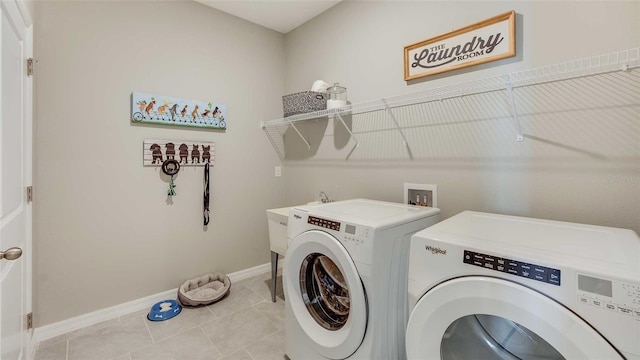 washroom featuring washer and clothes dryer and light tile patterned flooring