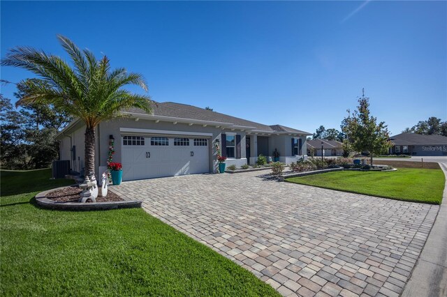 view of front of home with central air condition unit, a front yard, and a garage