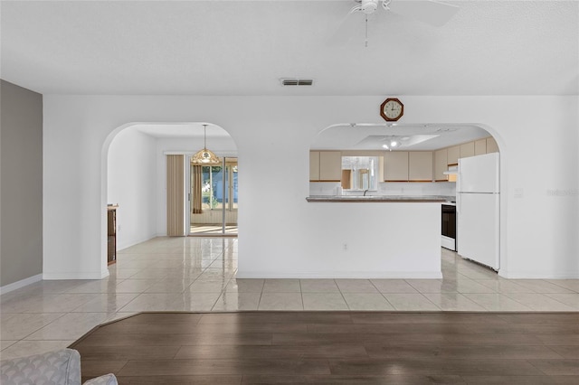 unfurnished living room featuring ceiling fan and light wood-type flooring