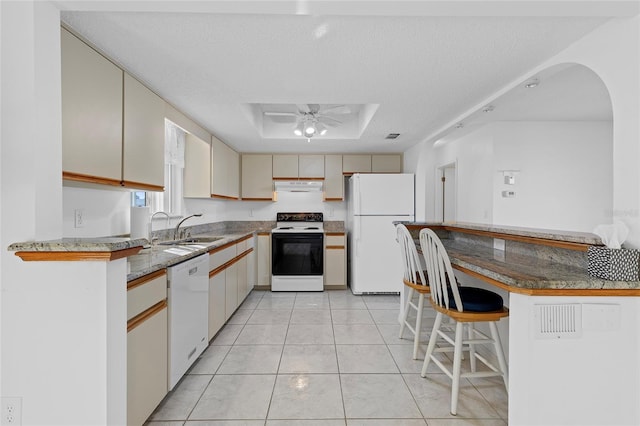 kitchen featuring ceiling fan, sink, cream cabinetry, a textured ceiling, and white appliances