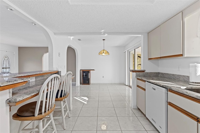 kitchen featuring a textured ceiling, dishwasher, white cabinetry, and hanging light fixtures