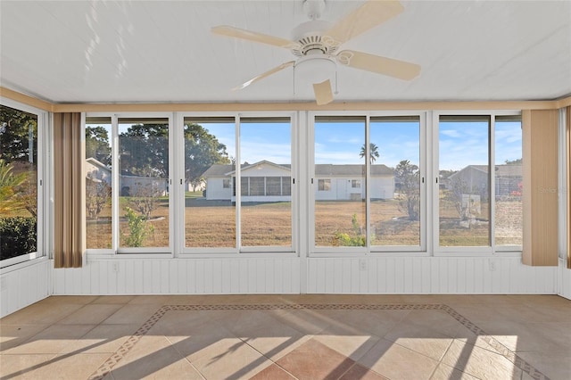 unfurnished sunroom featuring ceiling fan